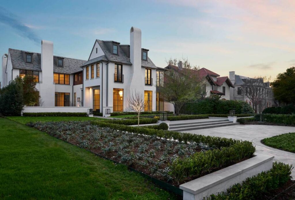 A large white house with a garden in front of it.