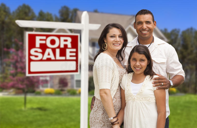 A family standing in front of their home for sale.